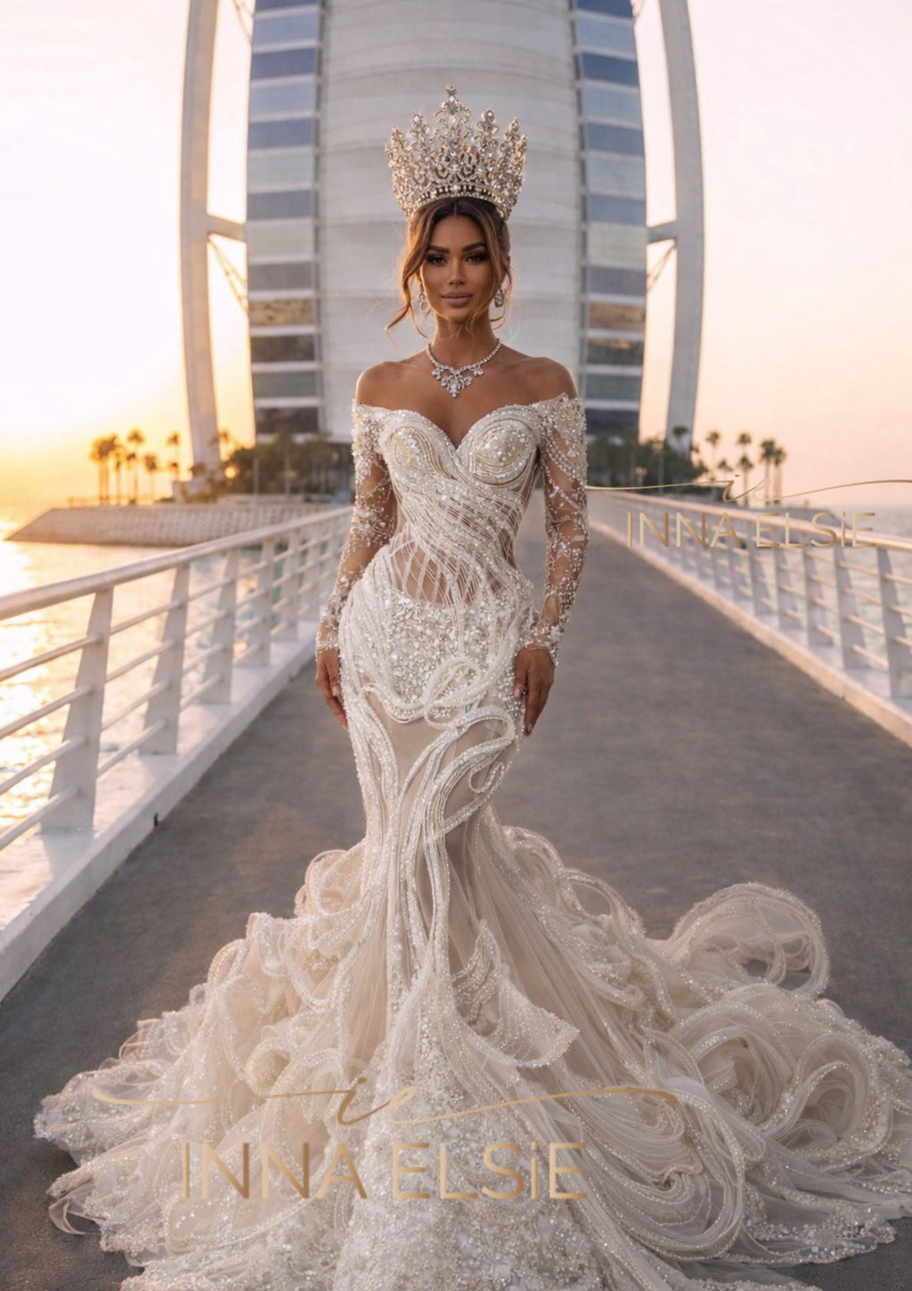 Woman in a white wedding dress with intricate detailing and a long train, standing on a bridge with a cityscape in the background.