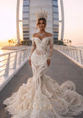 Woman in a white wedding dress with intricate detailing and a long train, standing on a bridge with a cityscape in the background.