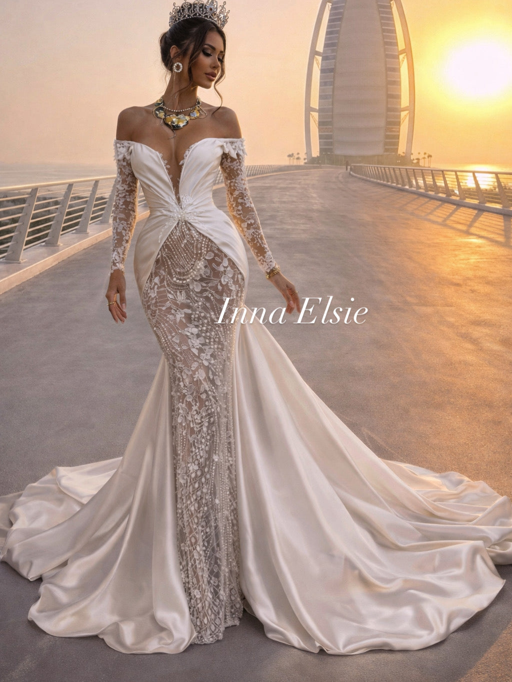 Woman in a white and silver gown with 'Ivana Elsie' branding against a sunset backdrop.