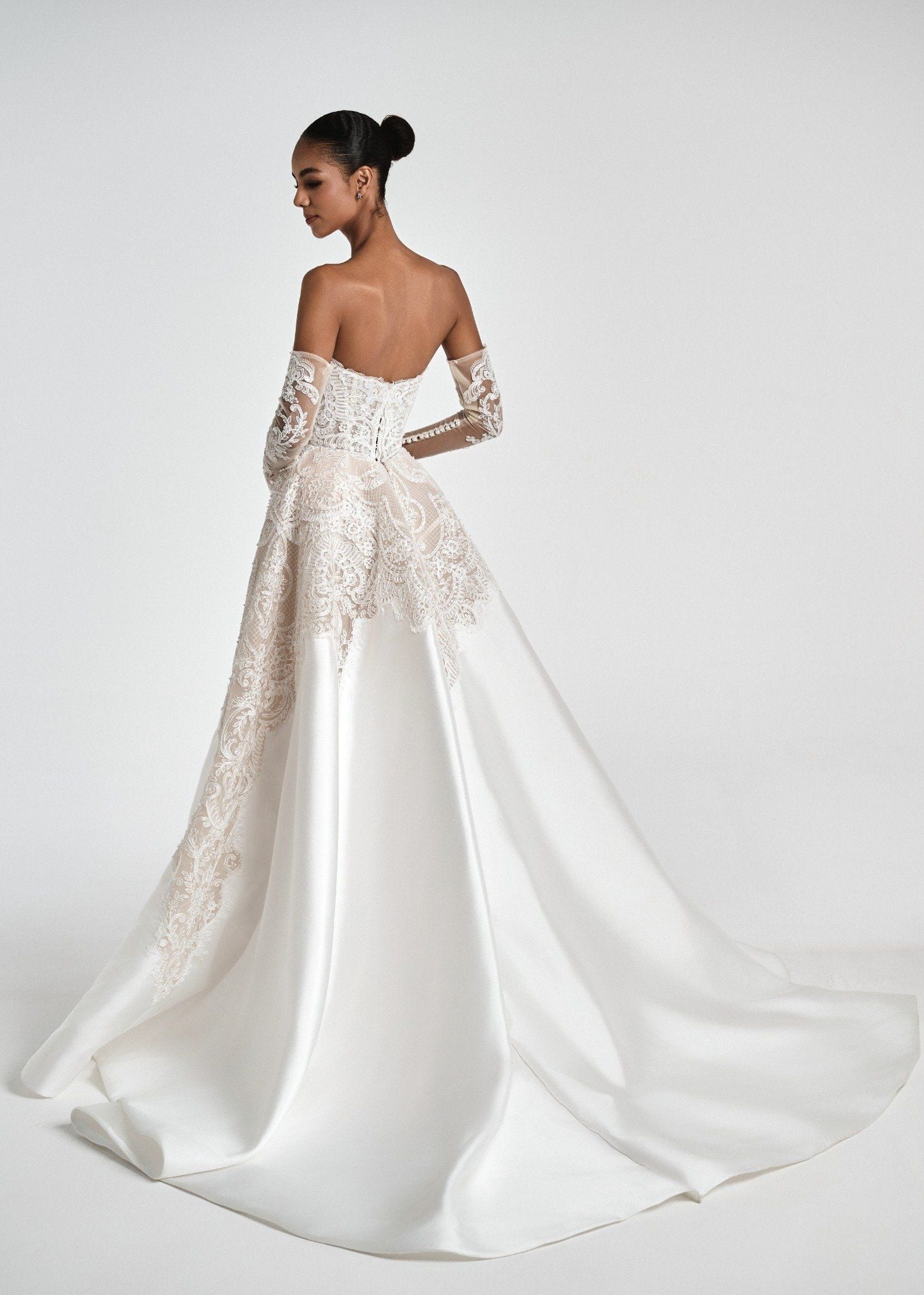 White lace wedding dress with long sleeves on a white background